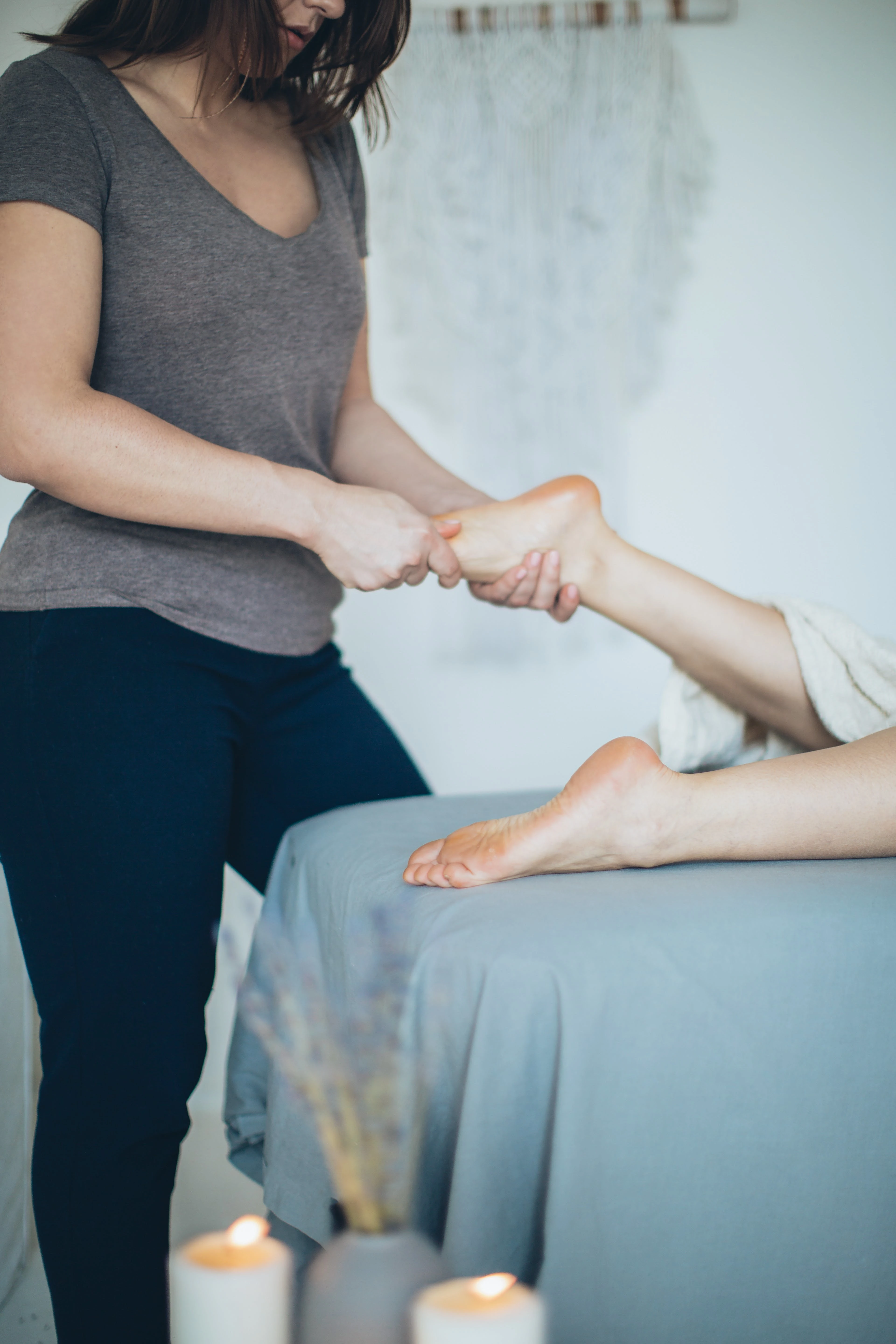 Orthopäde Barfußschuhe Eine Frau die aufgrund zu enger Schuhe an Fußproblemen leidet, wird von einer Orthopädin mittels einer Fußmassage behandelt.