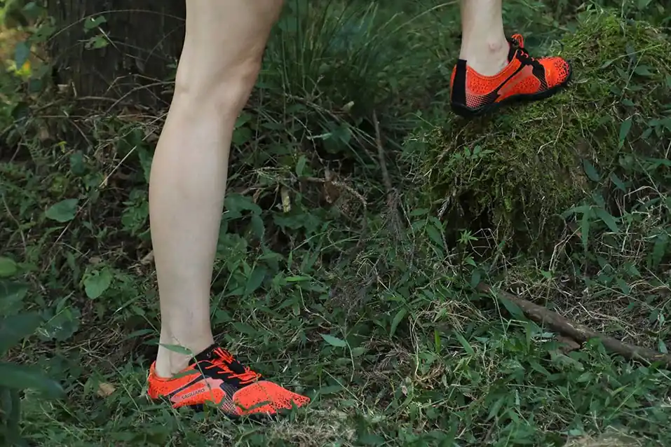 Ein Junger Mann wandert mit seinen Seguaro Barfußschuhen durch den Wald.