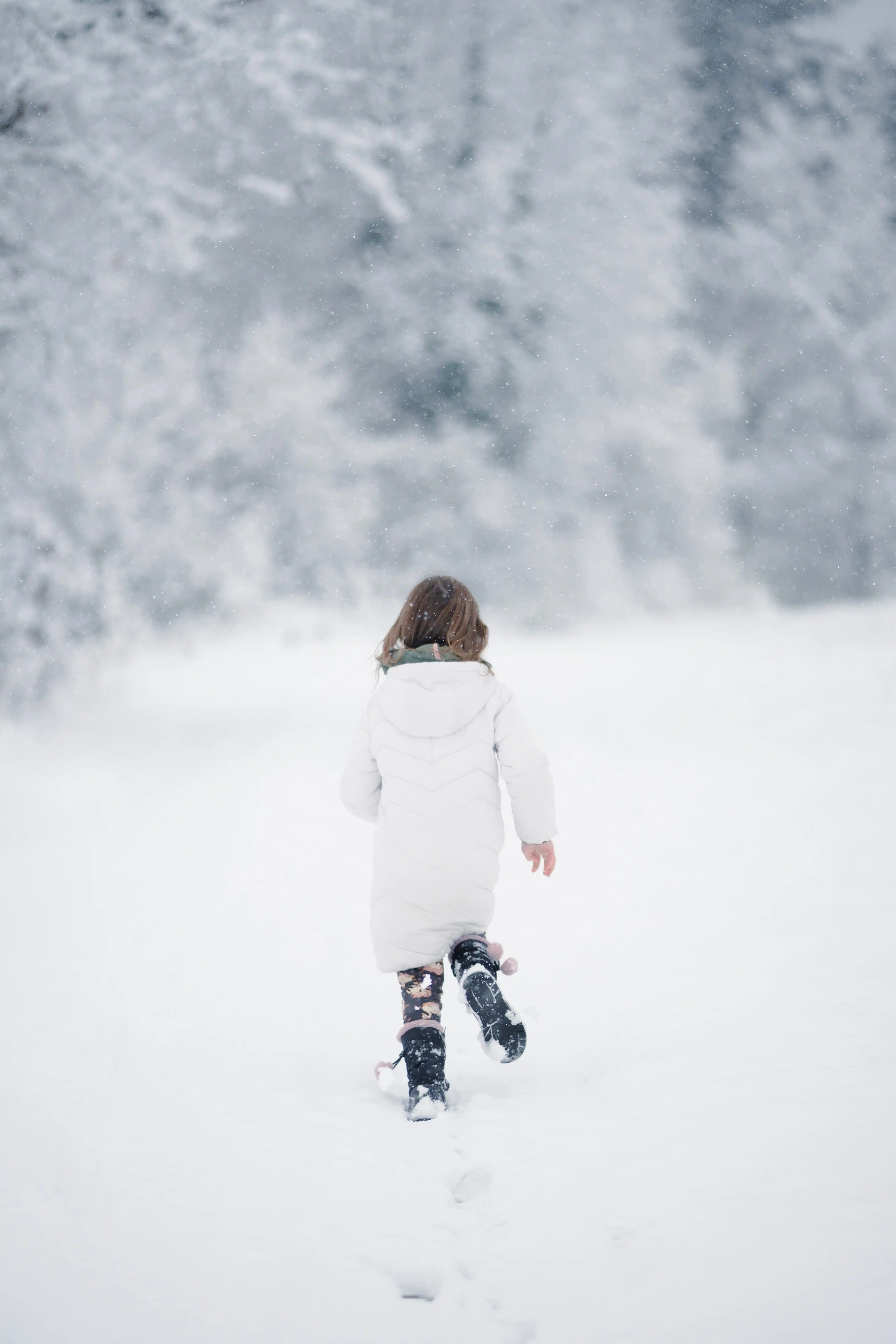Vorteile Barfußschuhe Winter Kinder Ein Kind rennt in seinen Barfußschuhen durch den Schnee.
